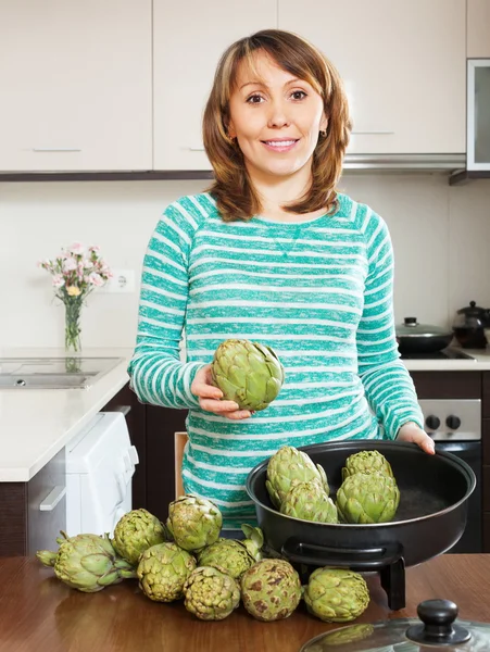 Happy woman cooking artichoke — Stock Photo, Image