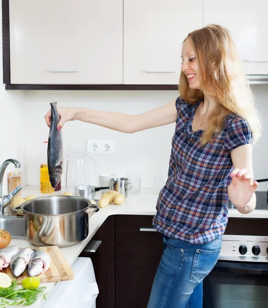 Sorridente donna bionda cucina pesce — Foto Stock
