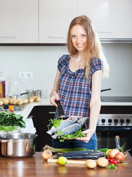 Woman cooking lubina fish — Stock Photo, Image