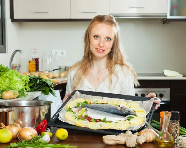 Woman cooking fish and potato in sheet pan — Stock Photo, Image