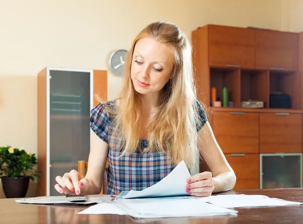 Serious long-haired woman fills in documents — Stock Photo, Image