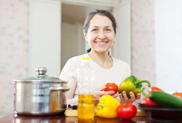 Zralá žena vaření vegetariánský oběd — Stock fotografie