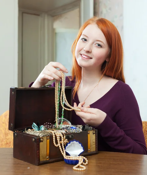 Chica mira joyas en cofre del tesoro — Foto de Stock