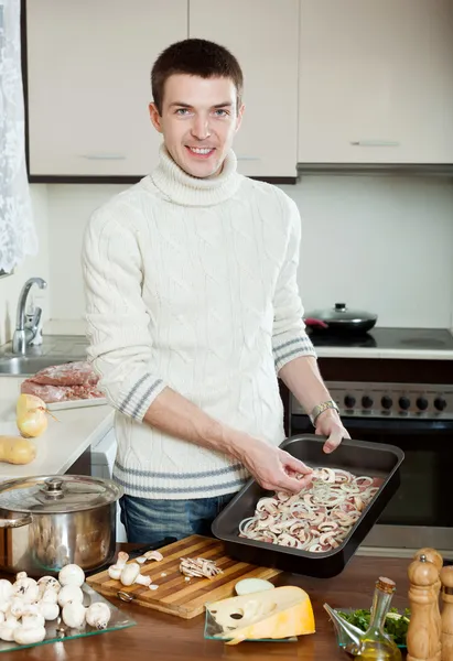 Guy koken van vlees met champignons — Stockfoto