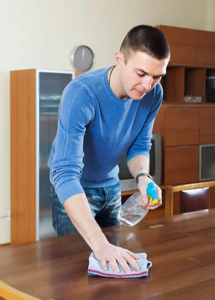 Man rengöra bord med trasa och rengöringsmedel — Stockfoto