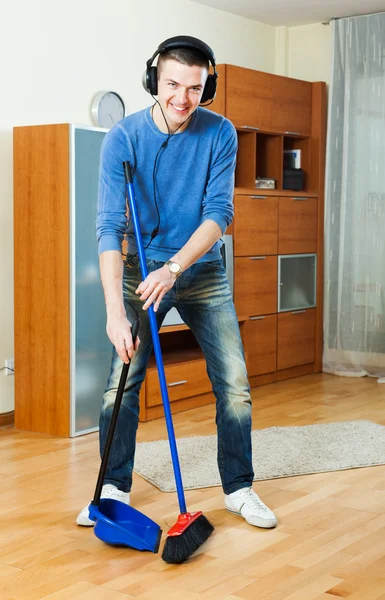 Homem varrendo pisos na sala de estar — Fotografia de Stock