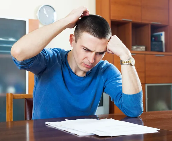 Hombre frustrado mirando el documento financiero — Foto de Stock