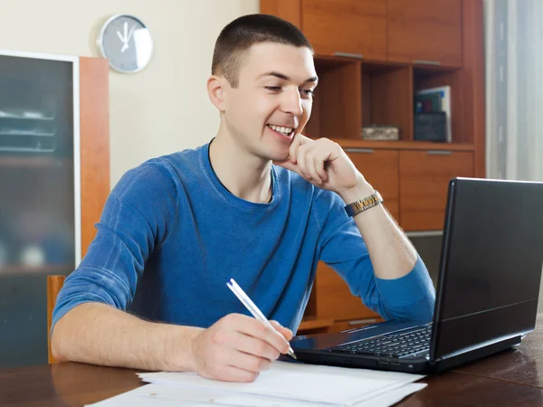 Uomo che fissa i documenti finanziari a tavola — Foto Stock