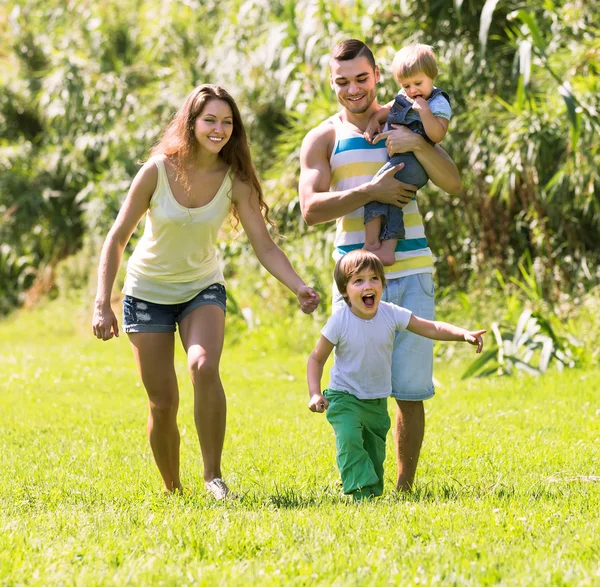 Czteroosobowa rodzina w słonecznym parku — Zdjęcie stockowe