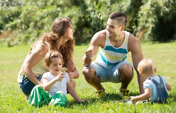 Familie van vier in zonnig park — Stockfoto