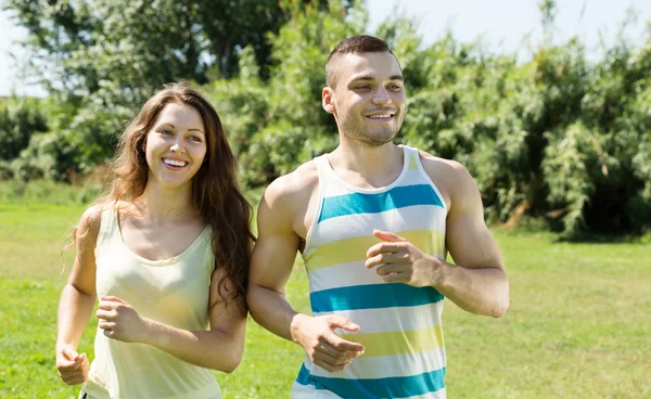 Joyeux jeune couple courir en plein air — Photo