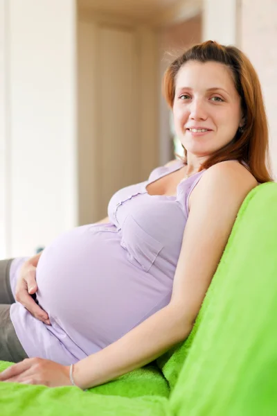 Pregnant woman on sofa Stock Picture