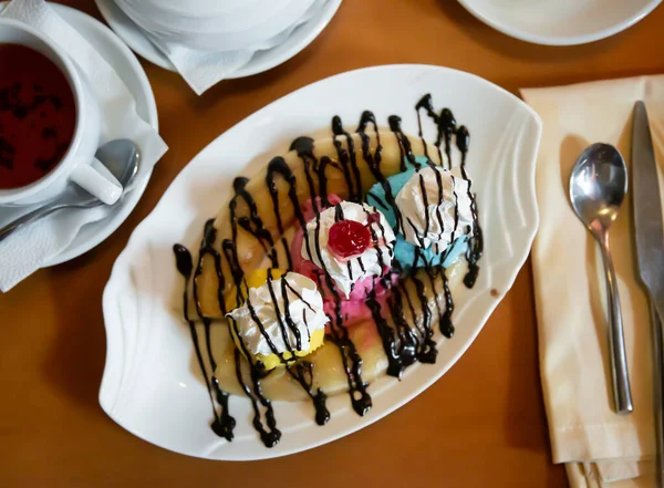 Helado a base de plátano partido con crema batida y salsa de chocolate — Foto de Stock