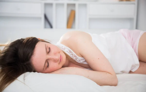 Linda chica en pygama durmiendo en la cama en el dormitorio en casa — Foto de Stock