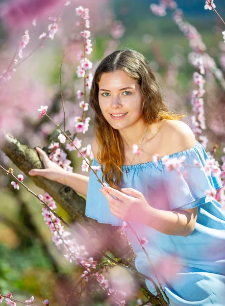 Frau in blauem Kleid posiert im blühenden Frühlingsgarten — Stockfoto