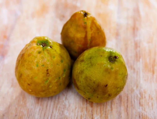 Drei frische, ungeschälte Guaven auf Holzgrund — Stockfoto