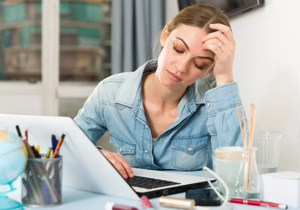 Empörte junge Frau zählt Familienbudget auf Laptop — Stockfoto