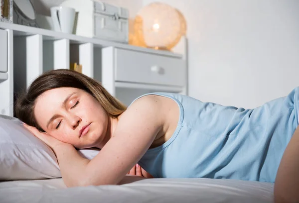 Retrato de menina relaxada no pijama dormindo na cama em casa — Fotografia de Stock