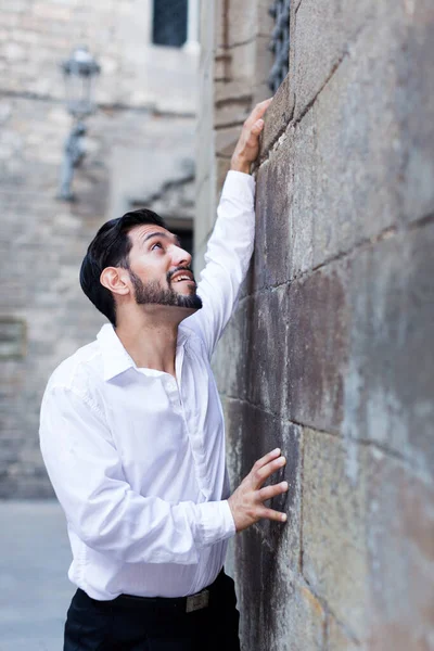 Homem perto da parede segurando as mãos para a janela — Fotografia de Stock