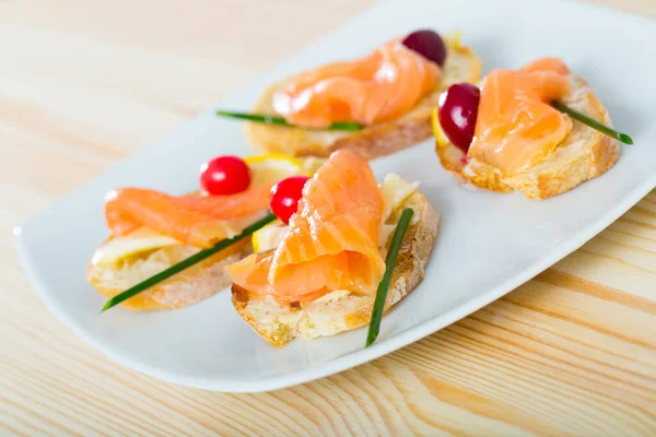 Tapas with salmon, lemon, cranberry — Stock Photo, Image