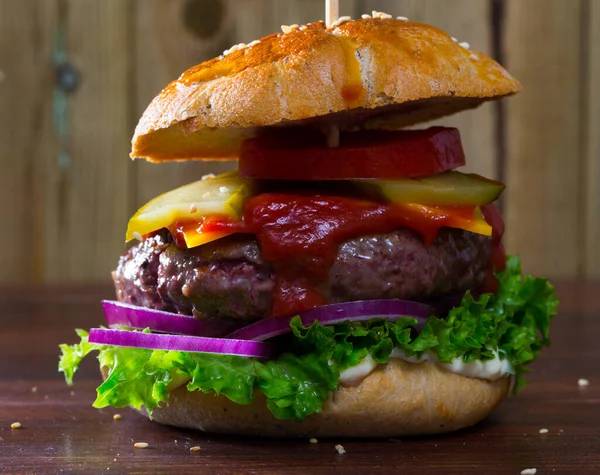 Gegrillter Hamburger mit Rindfleisch, Tomaten, Käse, Gurken und Ketchup — Stockfoto