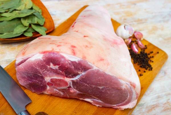 Pierna de cerdo cruda con hierbas y condimentos listos para cocinar —  Fotos de Stock
