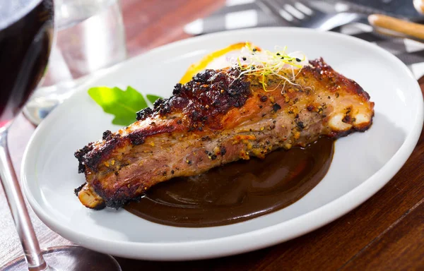 Zork ribs baked under mustard sauce served at plate with spiced sauce — Stock Photo, Image