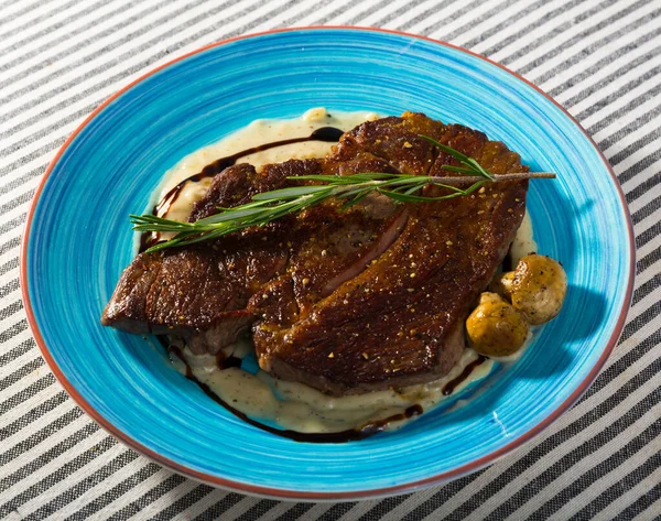 Fotografie van bord met runderentrecote met champignonsaus — Stockfoto