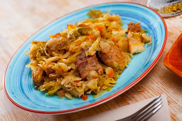 Appetizing cabbage stewed with pork meat on white plate — Stock Photo, Image