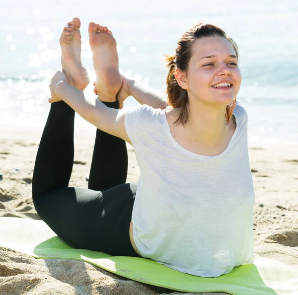 Female 20-30 years old is practicing asana in white T-shirt — Stock Photo, Image
