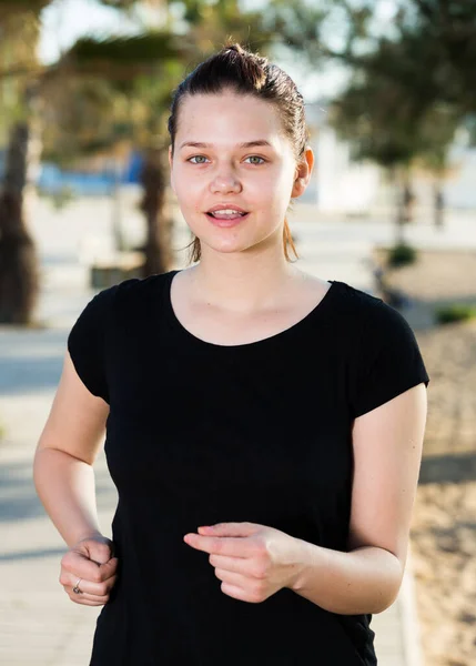 Atletische vrouw in zwart t-shirt is joggen — Stockfoto