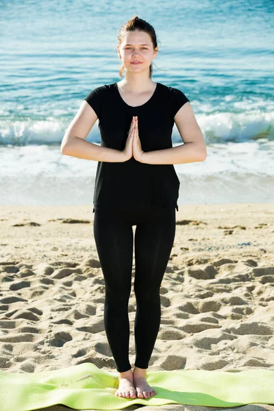 Siyah tişörtlü kız kalıyor ve meditasyon yapıyor. — Stok fotoğraf
