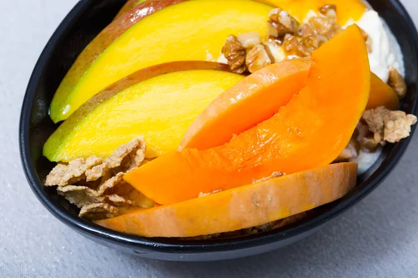 Lekkere pompoen en mango geserveerd met slagroom en havervlokken op bord — Stockfoto