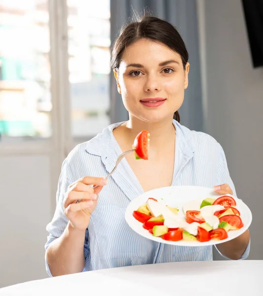 Женщина ест салат за столом — стоковое фото
