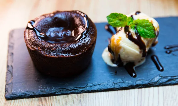 Vanilyalı dondurmayla servis edilen tatlı lav keki ve siyah tabakta nane şekeri. — Stok fotoğraf