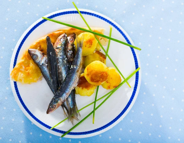 Draufsicht auf gebratene Sardinen mit Kartoffelkroketten, Focaccia auf blauer Tischdecke — Stockfoto