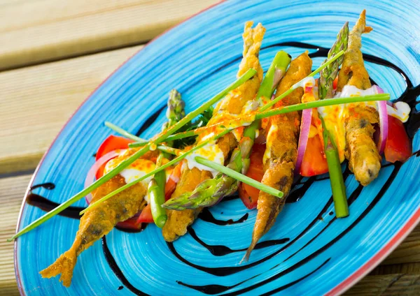 Sardines fried in batter with creamy ginger sauce on cushion of sweet tomatoes — Stock Photo, Image