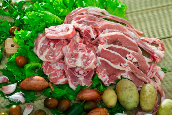 Assortimento di agnello crudo e verdure su scrivania in legno naturale — Foto Stock