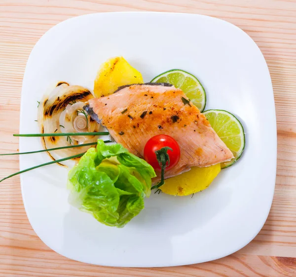 Top view of baked trout fillet with potatos on white plate — Stock Photo, Image