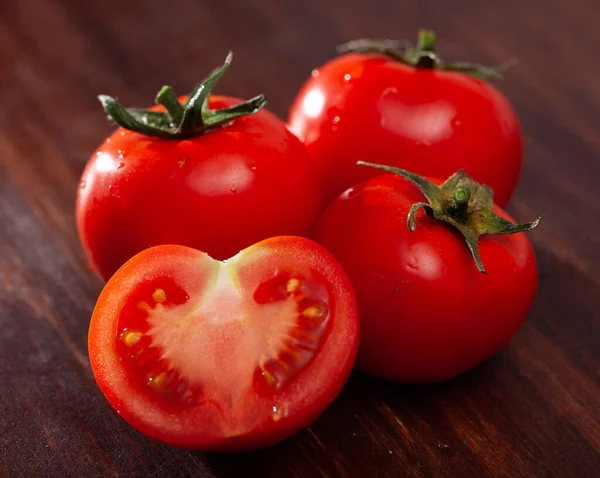 Lekkere smakelijke tomaten op een houten ondergrond — Stockfoto