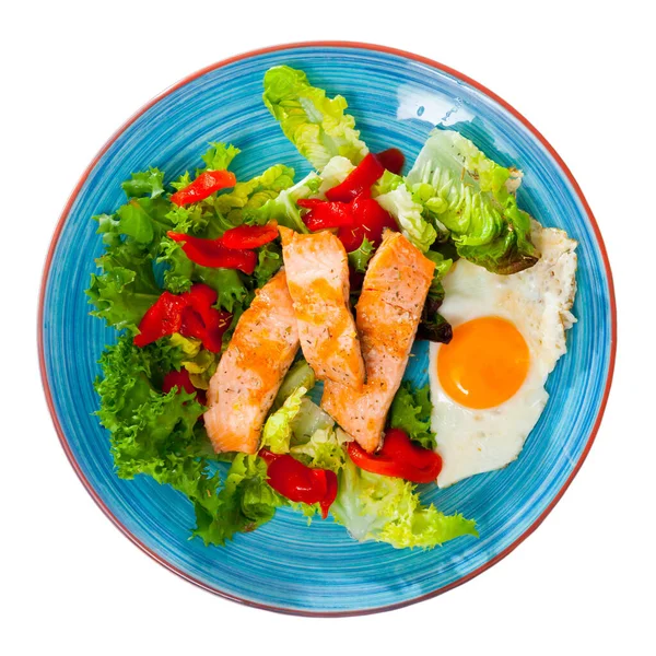 Obraz płyty z smażonym pstrągiem, jajkiem, warzywami i zieloną sałatą — Zdjęcie stockowe