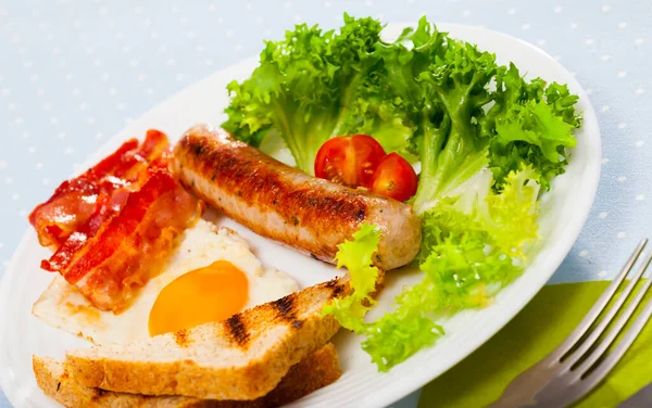 Sült tojás szalonnával, kolbásszal, kenyérrel — Stock Fotó