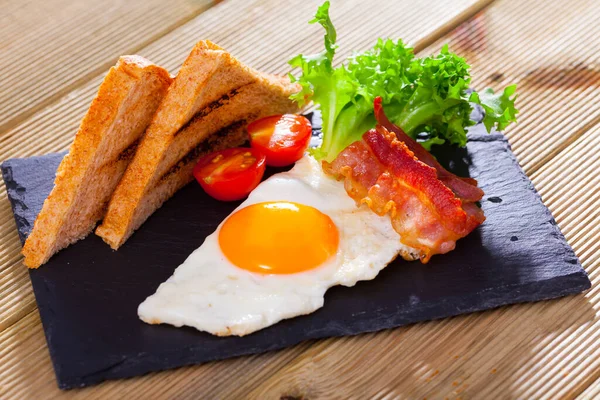 Desayuno con huevo frito, tocino y pan a la parrilla —  Fotos de Stock