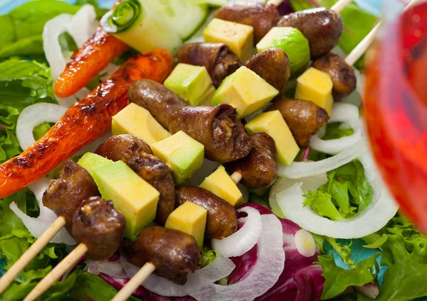 Tavuk kalbinden lezzetli şiş kebap, avokado ve marul tabakta. — Stok fotoğraf