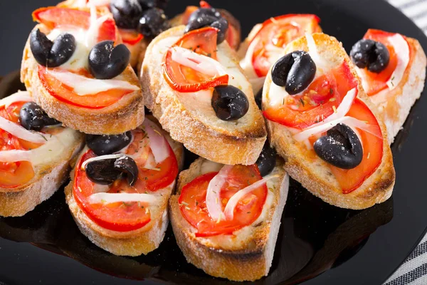 Toasts with tomatoes and black olives — Stock Photo, Image