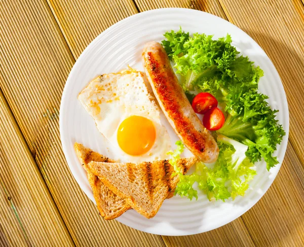 Vista superior de huevos fritos con salchichas, pan y verduras — Foto de Stock