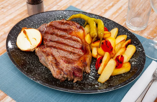 Talíř z grilovaného hovězího a brambor na stole v restauraci, výhled shora — Stock fotografie
