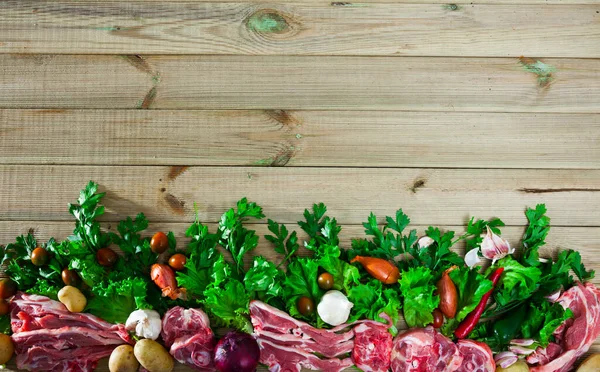 Dřevěné pozadí se syrovým jehněčím, zeleninou, zeleninou — Stock fotografie