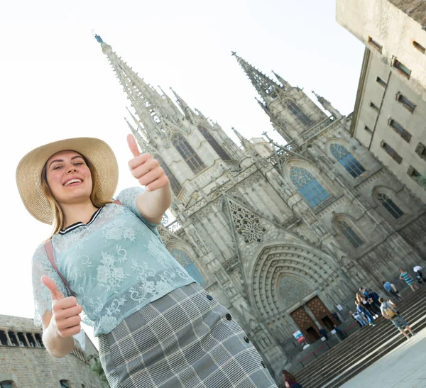 Emotionele vrouw in hoed houdt duimen omhoog, loopt in de Europese stad — Stockfoto