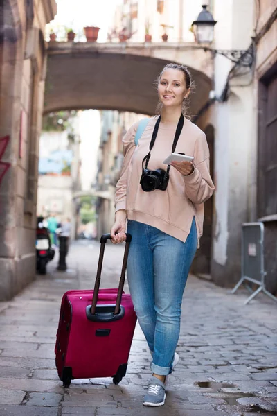 Jonge vrouw met pamflet op zoek naar route — Stockfoto